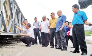  ??  ?? RAHMAN (depan) melihat sendiri keadaan jambatan Kampung Gantisan bersama rombongan lawatan kerja.