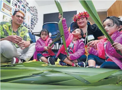  ?? Photo: ROBYN EDIE/FAIRFAX NZ 630966979 ?? Stephen and Maggie Torotoro enjoy some flax weaving with their triplet daughters Kimmy, Angel and Joanita, 3.