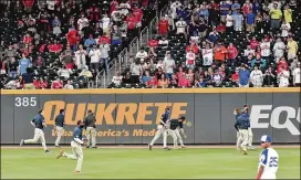  ?? HYOSUBSHIN/HYOSUB.SHIN@AJC.COM ?? The grounds crew cleans trash from the field after the Braves lost a replay challenge to a call that gave the Phillies a 7-6 lead in the ninth inning Sunday.