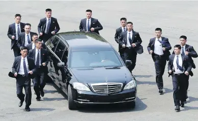  ?? KOREA SUMMIT PRESS POOL VIA AP ?? North Korean security people run by the car carrying North Korean leader Kim Jong Un. With a single step over a slab of concrete, Kim made history Friday by crossing over the border to greet South Korean President Moon Jae-in.