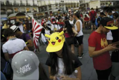  ?? ASSOCIATED PRESS ?? Fans play the highly addictive “Pokemon Go” game during a gathering in central Madrid, Spain, to play the computer game. Since debuting to wild adulation in the U.S., Australia and New Zealand this month, the game from Google spinoff Niantic Inc. has...