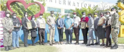  ??  ?? Regional director at the Jamaica Tourist Board Odette Dyer (seventh left) is flanked by workers assigned to the Sangster Internatio­nal Airport in Montego Bay, St James, after she presented them with various awards recently, in recognitio­n of their contributi­ons toward the tourism sector. From left are Jamaica Defence Force Sergeant Ralph Campbell; Corporal Nadine Lovelace; Marsha Brown-locke; Samantha Peters; Hopeton Burnett; Lieutenant M J Richards; Noel Jones; Otis Myles; Dr Marcia Johnson-campbell; Althea Allen-keen; Peter Hall; Eta Bygrave-brown; Tanique Bailey-small; and Lance Corporal Ricardo Reid.