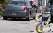  ?? THE ASSOCIATED PRESS ?? A car drives past HitchBOT, a hitchhikin­g robot, on July 17 in Marblehead, Mass.