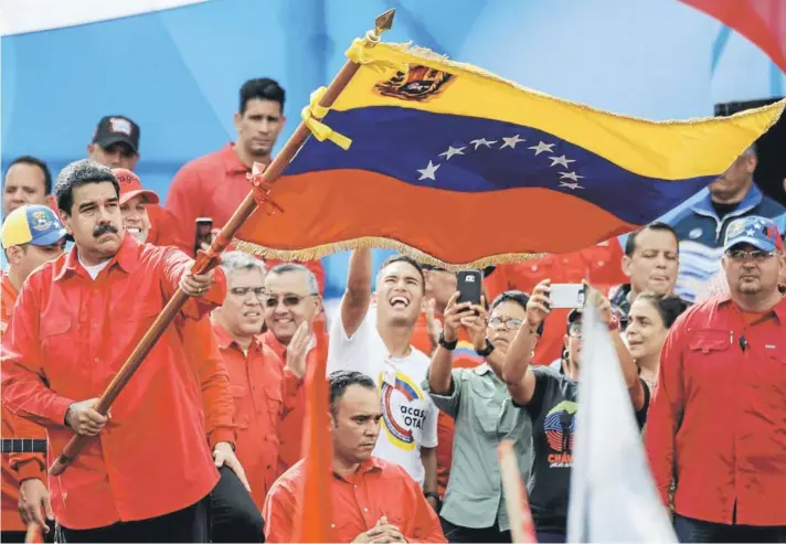  ??  ?? Nicolás Maduro hace flamear una bandera venezolana durante el cierre de campaña para la Constituye­nte, el jueves, en Caracas.
