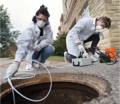  ?? MATHEW MCCARTHY
WATERLOO REGION RECORD FILE PHOTO ?? University of Guelph engineerin­g students Melissa Novacefski and Jonathan Evans pump wastewater from a sewer outside a student residence in 2020 to test for the presence of COVID-19.