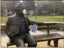  ??  ?? A note and face mask are seen on a statue in a downtown park filled with smoke from a wildfire in Sonoma, Calif., on Thursday.