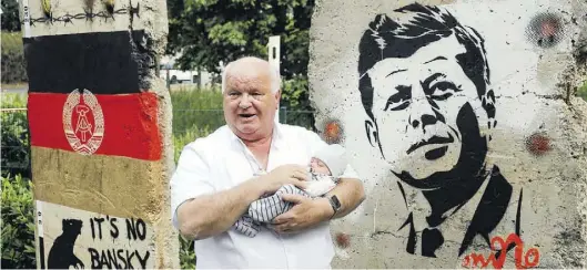  ?? BILD: MARTIN REMMERS ?? Hans Höffmann ließ zwei Stücke der Berliner Mauer im Garten der Oldenburge­r Senfmühle aufstellen, wo ein neuer Standort seiner Firma entsteht. Auch seine sechs Wochen alte Enkelin Chiara Marie war dabei.