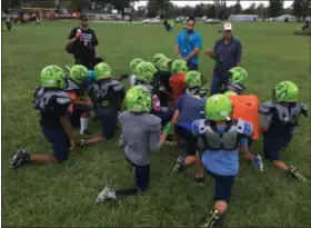  ?? RICHARD PAYERCHIN — THE MORNING JOURNAL ?? From left, coaches Anthony Atkinson Jr., Xavier Atkinson and Anthony Atkinson talk to players of the Lorain County Raging Raptors youth football team at practice Oct. 2, at Gen. Johnnie Wilson Park in South Lorain. The league this year has 65 boys in football and 35 girls in its cheering program.