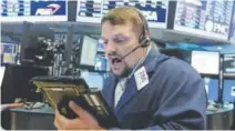  ?? Richard Drew, The Associated Press ?? Trader Michael Milano works Thursday on the floor of the New York Stock Exchange.