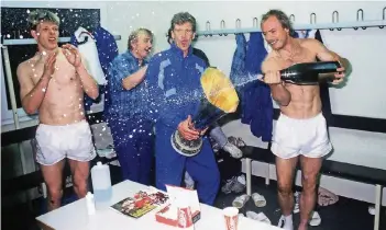  ?? FOTO: IMAGO ?? Schampus, Zucker und Cola-Becher: Knut Reinhardt (li.) in der Kabine von Bayer Leverkusen nach dem Uefa-Pokalsieg 1988 mit (v.li.) Co-Trainer Gerd Kentschke, Christian Schreier und Klaus Täuber.