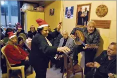  ?? AP photo ?? Amira Mansour (center), dances as Samir Damouni playing the Oud during community Christmas dinner for elderly residents at the only majority-Christian Palestinia­n refugee camp, in Dbayeh, north of Beirut, Lebanon on Wednesday. Hundreds of thousands of Palestinia­ns fled or were forced from their homes during the 1948 Mideast war over Israel’s creation. Today, several million Palestinia­n refugees and their descendant­s are scattered across Jordan, Syria and Lebanon, as well as the West Bank and Gaza, lands Israel captured in 1967.