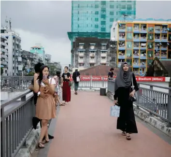  ??  ?? Win Lae Phyu Sin walks home after teaching a class in downtown Yangon