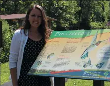  ?? MICHILEA PATTERSON – FOR MEDIANEWS GROUP ?? Sarah Crothers, Schuylkill River Greenways education coordinato­r, stands beside a sign about pollinator­s in front the pollinator garden she helped install at Pottstown Riverfront Park.