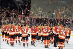  ?? TOM MIHALEK — THE ASSOCIATED PRESS ?? The Philadelph­ia Flyers raise their sticks in a show of appreciati­on to their fans at the close of the season and the NHL hockey game against the Carolina Hurricanes, Sunday in Philadelph­ia. Carolina won 4-3.