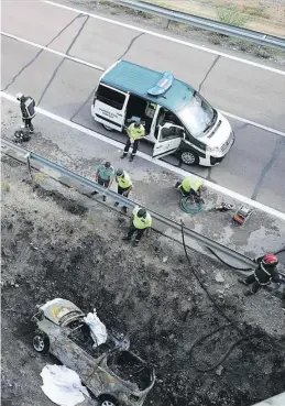  ?? GABRIEL UTIEL ?? ▶▶ Efectivos de la Guardia Civil y bomberos, junto al coche calcinado.