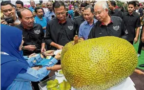  ??  ?? Jackpot jackfruit: Najib and Agro-based Industry Minister Datuk Seri Ahmad Shabery Cheek (third from right) with a giant jackfruit weighing in at 30kg in Serdang. The fruit has been a major draw at the expo. — Bernama