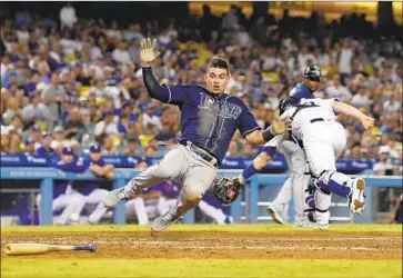  ?? Mark J. Terrill Associated Press ?? WILLY ADAMES of the Tampa Bay Rays scores in the sixth inning at Dodger Stadium on a throwing error by center fielder Cody Bellinger. Bellinger’s throw eluded catcher Will Smith after a single by Jesus Aguilar.