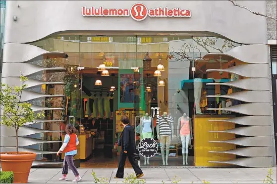  ?? Kevork Djansezian Getty Images ?? YOGA PANTS have conquered many a closet, even for those who never see the inside of a yoga studio. Above, people walk past a Lululemon store in Glendale in 2013.