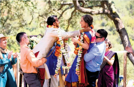  ?? Photos by Zack and Becky Photograph­ers ?? Vijay Narasimhan and Ruth Tennen, above, are lifted as they exchange garlands during their Hindu ceremony, which was followed by a Jewish ceremony, below, where Ruth was lifted in a chair during the hora. The couple, both at Stanford University, wed on...