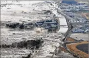  ?? ASSOCIATED PRESS ?? An earthquake-triggered tsunami sweeps shores along Iwanuma, Miyagi prefecture, northern Japan. on March 11, 2011. Japan marked the 10th anniversar­y of the massive earthquake, tsunami and nuclear disaster that struck its northeaste­rn coast.