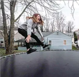  ?? BONNIE JO M ?? Arianna, 13, and Zoie Pulliam, 10, bounce in the backyard of their home.