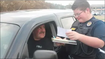  ?? DESTIN DAVIS/THE Saline Courier ?? Max Birmingham, a Bauxite student who suffers from Prader Willi Syndrome, got the chance to be a Junior Deputy for a day with the Saline County Sheriff’s Office to celebrate his 13th birthday. He even got the chance to write a ticket at a staged traffic stop.