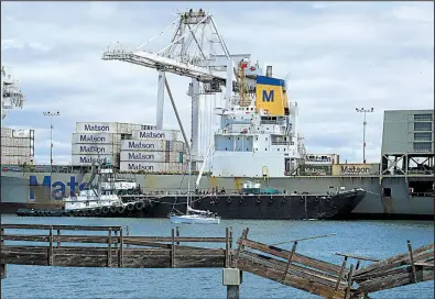  ?? AP ?? Workers unload a container ship this spring at the Port of Oakland, Calif. The U.S. economy grew in the first quarter at a slower pace than previously estimated.