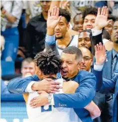  ?? AP PHOTO/KEITH SRAKOCIC ?? Pittsburgh coach Jeff Capel, center, hugs Trey McGowens after the Panthers upset Florida State on Jan. 14.
