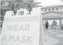  ?? JOHN MCCALL/SOUTH FLORIDA SUN SENTINEL ?? A sign alerts beachgoers to wear a mask near Anglin’s Pier in Lauderdale-by-the-Sea on Wednesday.
