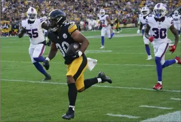  ?? Matt Freed/Associated Press ?? Steelers running back Jaylen Warren runs for a touchdown in August 2023 against the Buffalo Bills. Pittsburgh fans are hoping to see scenes like this Sunday when the teams meet in the AFC playoffs in Buffalo.