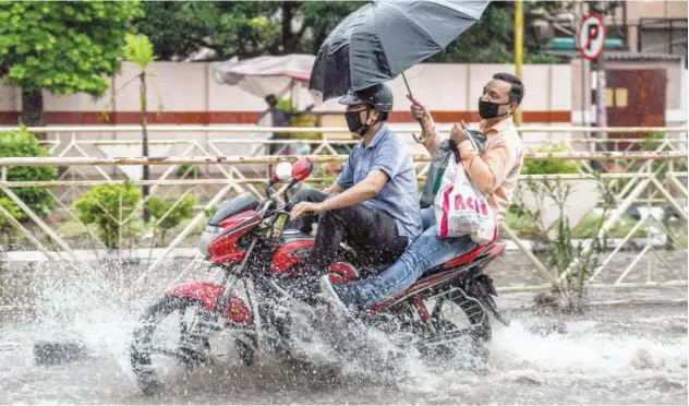  ?? Agence France-presse ?? ↑ Commuters make their way through a water-logged street after heavy rain in Amritsar, Punjab, on Monday.