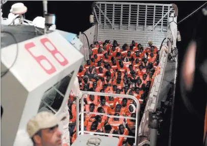  ?? Kenny Karpov ?? The Associated Press Migrants prepare to board the aid group SOS Mediterran­ee’s Aquarius ship on Monday in the Mediterran­ean Sea. Italy and Malta dug in for a second day and refused to let the rescue ship with 629 people aboard to dock in their ports,...