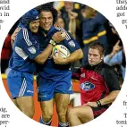  ??  ?? 2003 was the last time the Blues won a trophy. Sam Tuitupou, left, congratula­tes tryscorer Doug Howlett as a grim Richie McCaw, right, looks on.