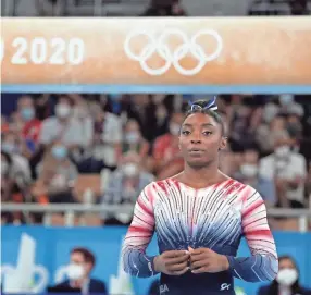  ?? GREGORY BULL/AP ?? Simone Biles waits to compete on the balance beam during the artistic gymnastics women’s apparatus final at the Summer Olympics on Aug. 3 in Tokyo.