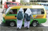  ?? BOY SLAMET/JAWA POS ?? HARUS TEREALISAS­I: Dua pelajar naik angkot di kawasan Jenggolo. Dishub mematangka­n rencana angkutan gratis untuk pelajar.