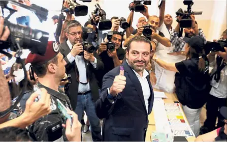  ?? — Reuters ?? Exercising his right: Hariri showing his ink-stained thumb after casting his vote during the parliament­ary election in Beirut, Lebanon.