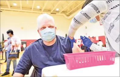  ?? Peter Hvizdak / Hearst Connecticu­t Media ?? Engineerin­g and Science Education teacher Roger Rushworth of the University Magnet School receives his COVID-19 vaccinatio­n at the Wilbur Cross High School gym on Tuesday.