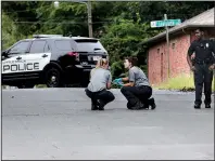  ?? Arkansas Democrat-Gazette/THOMAS METTHE ?? Members of the Little Rock police’s Crime Scene Search Unit collect evidence on West 31st Street after a man was killed Sunday.