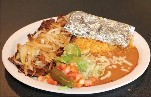  ?? NORTHWEST ARKANSAS DEMOCRAT-GAZETTE ?? The carne asada combines steak with grilled onions and is served with tortillas, rice, beans and guacamole.