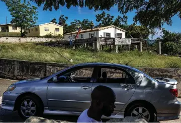  ??  ?? Roofers work on a home in St. Thomas on Mar 6. Virgin Islands residents are still recovering after back-to-back hurricanes in 2017.