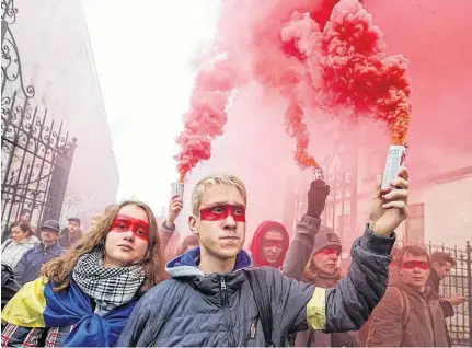  ?? VALENTYN OGIRENKO REUTERS ?? People burn flares during a rally against the approval of the so-called Steinmeier Formula, in Kiev, Ukraine, Oct. 6.