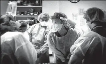  ?? DR. MOLLY GRASSINI ?? stares at a heart monitor while trying to resuscitat­e a patient in cardiac arrest.