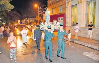  ??  ?? La imagen de María Auxiliador­a es llevada en andas hasta el templo.