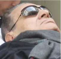  ?? (Reuters) ?? HOSNI MUBARAK, former Egyptian president, lies on a gurney at his trial in Cairo yesterday.