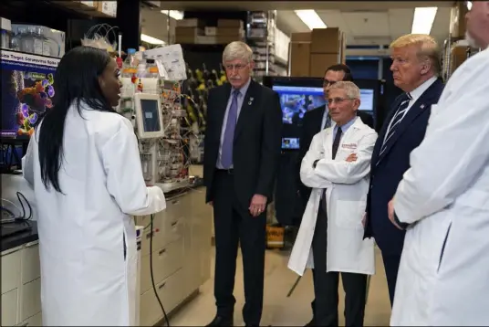  ?? Evan Vucci The Associated Press ?? Dr. Kizzmekia Corbett, of Viral Pathogenes­is Laboratory, talks March 3 with President Donald Trump at the National Institutes of Health in Bethesda, Md. A vaccine developed by Moderna Inc. with the National Institutes of Health is being tested on 30,000 volunteers across the country.
