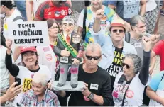  ??  ?? Brasileños protestaro­n ayer en Río de Janeiro contra el presidente Michel Temer. En el cartel de una manifestan­te se lee: “Temer, el ingenuo corrupto”.