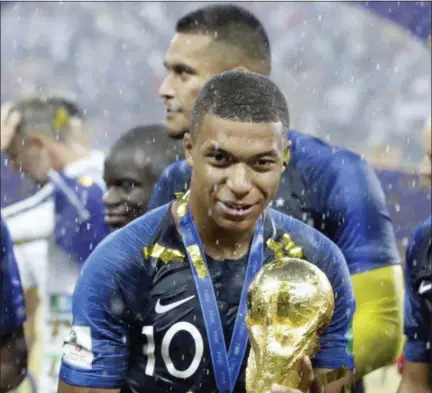  ?? MATTHIAS SCHRADER — ASSOCIATED PRESS ?? France’s Kylian Mbappe celebrates with the trophy after his team’s win over Croatia at Luzhniki Stadium in Moscow on Sunday.