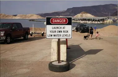  ?? JOHN LOCHE—ASSOCIATED PRESS ?? A sign warns of low water levels at a boat ramp on Lake Mead at the Lake Mead National Recreation Area, Friday, Aug. 13, 2021, near Boulder City, Nev. Water levels at Lake Mead, the largest reservoir on the Colorado River, have fallen to record lows.