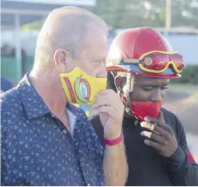  ?? (Photos: Joseph Wellington) ?? Trainer Gary Subratie (left) and jockey Robert Halledeen working out their strategy before the start of the race with Sentient.