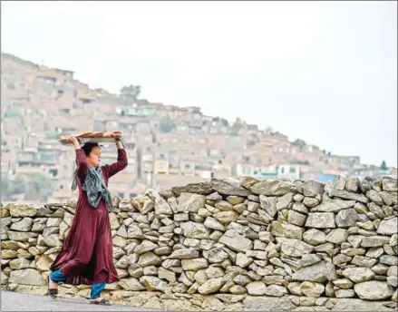  ?? HOSHANG HASHIMI/AFP ?? A young girl carries bread on a tray over her head at a hillside overlookin­g Kabul on Sunday as the US-led interventi­on in Afghanista­n enters its 19th year.